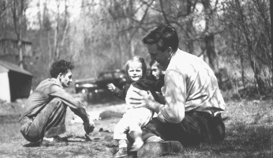 Woody Guthrie, agachado, con Alan Lomax y la hija de éste, 1946